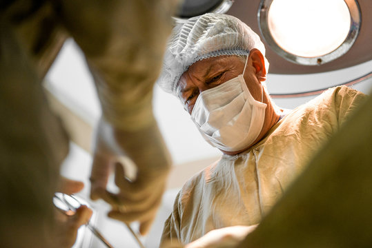 Kiev, Ukraine - 11 march 2016: Documentary during the surgery at the hospital. Concentrated surgeon doing operation under operation light