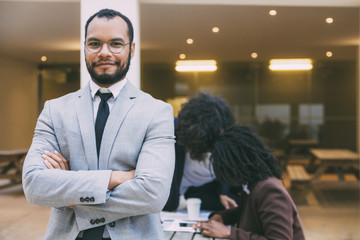Happy confident male professional posing with arms folded, looking at camera, smiling. Her...