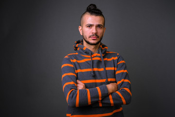 Portrait of handsome bearded Turkish man in hoodie with arms crossed