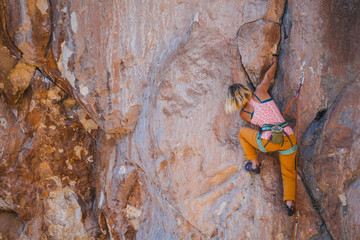 A girl climbs a rock.