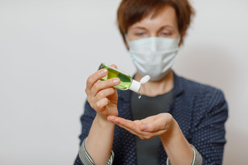 Woman in protective mask and with antibacterial antiseptic gel for hands disinfection and health protection prevention during flu virus outbreak, epidemic and infectious diseases