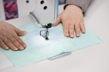 Experienced seamstress sews fabric protective masks as standard during the COVID-19 epidemic.