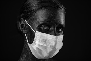Coronavirus, masked woman. Studio portrait of a young woman wearing a face mask, looking at camera, on black background. Influenza epidemic, dust allergy, virus protection. City air pollution concept
