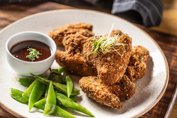 Fried chicken wings with sugar peas and herbs