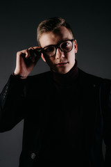 A young male journalist with glasses near a typewriter.