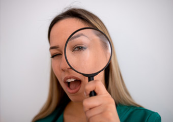 Woman looking through magnifying glass