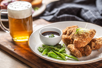 Fried chicken wings with sugar peas herbs and draft beer