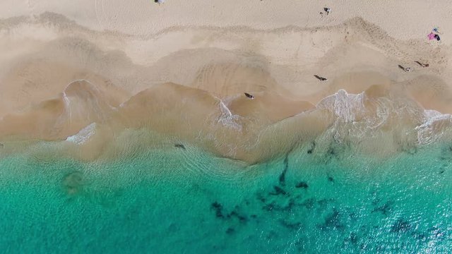 Top view on beach and people walking near water. Coast of Atlantic Ocean in Morro Jable, Fuerteventura Spain 