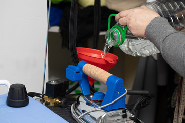 The employee replenishes distilled water in a professional iron tank.