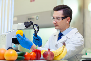 Laboratory worker examining fruits and vegetables and making analysis for pesticides and nitrates.