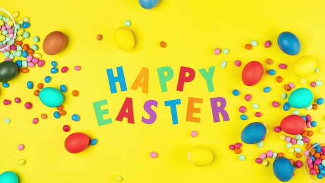 Stop motion animation with colored eggs and colored letters Happy Easter on a yellow background. Happy easter concept