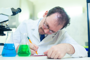 Chemist crazy. A mad scientist conducts experiments in a scientific laboratory. Intently records the results of the study. COVID-19. COVID Coronavirus