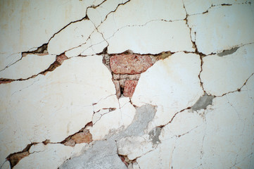 Abstract texture and background of broken plastered cement wall with red bricklayers inside