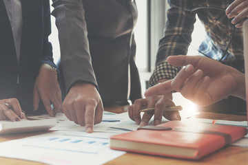 Businesswoman holding pens and holding graph paper are meeting to plan sales to meet targets set in...