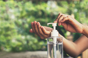 Women using alcohol gel, hand sanitizer, hand dispensing pump