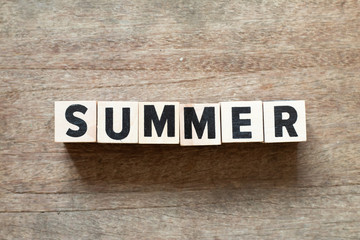 Letter block in word summer on wood background