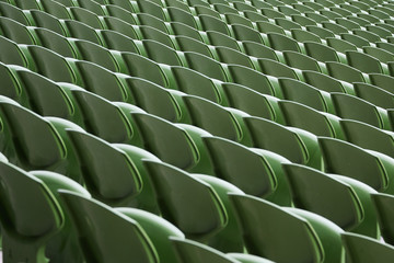 A row of empty green seats in a football stadium