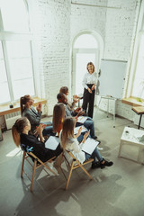 Advanced. Female speaker giving presentation in hall at workshop. Business centre. High angle view...