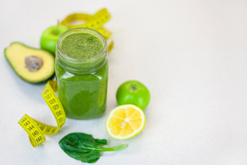Fototapeta premium Healthy green smoothie with apple, spinach, lemon and measuring tape. Fitness trend - food for weight loss. Morning detox for a healthy lifestyle, ketone diet, raw food diet