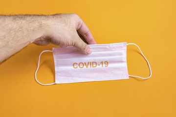 Man's hand holding surgical mask