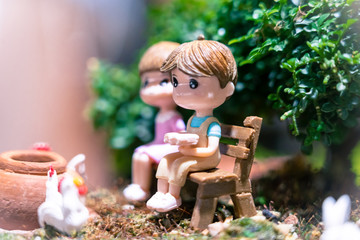 a plastering toys; boy and girl, in the garden, under the tree. lovely moment, couple time.