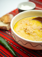 traditional romanian dish tripe soup known as ciorba de burta served with cream and pepper