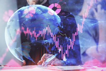 Double exposure of businessman working on laptop on background. International business hologram in...