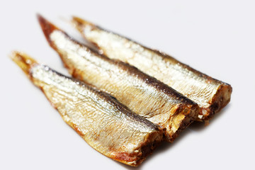 Hot smoked sprats or in oil on a white background. Small salted fish.