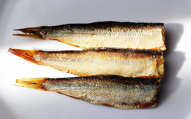 Hot smoked sprats or in oil on a white background. Small salted fish.