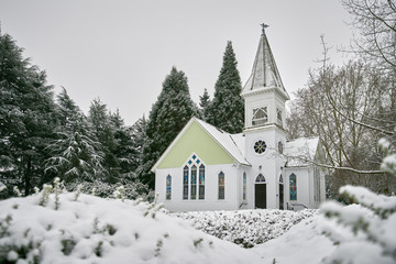 Fototapeta na wymiar Winter Church and Fresh Snow. The historic Richmond Chapel in Minoru Park with a blanket of fresh snow.