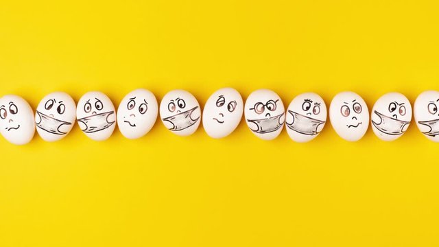 Eggs with painted faces move endlessly on a yellow background. Emotions on the eggs. Stop motion animation