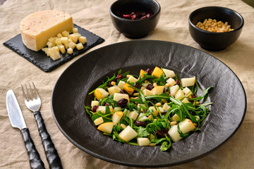 Arugula Salad with Pear on a black plate