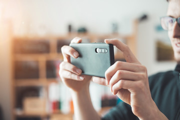 Social media content production with the smartphone. Close up of black smartphone camera lens indoors.