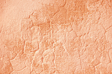 Fragment of old house wall close-up. Pink background. Peeling plaster on concrete surface. Cracks in paint. Copy space. Place for text. Selective focus image.