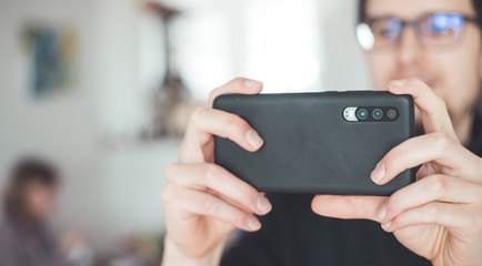 Social media content production with the smartphone. Close up of black smartphone camera lens indoors.