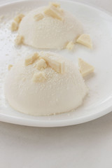 Fototapeta na wymiar Delicious italian dessert panna cotta with milk chocolate on a plate on white background