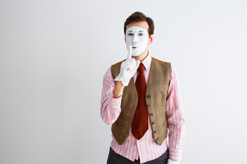 Portrait of man, actor, pantomime, man making finger gesture quieter. Emotions, facial expressions,...