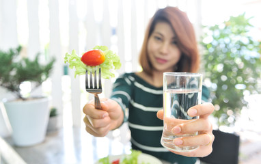 Vegetables and drinking water for good helth,Asian women invite vegetables and drinking water,Selective focus