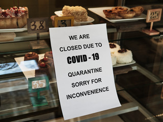 Biohazard concept of living in a new reality of coronavirus epidemic hysteria cafe owner sticks advertisement on quarantine measures to contain virus pinned on dessert display cabinet
