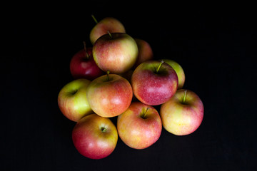 Fresh harvest of red apples on a black background, farm organic fruits