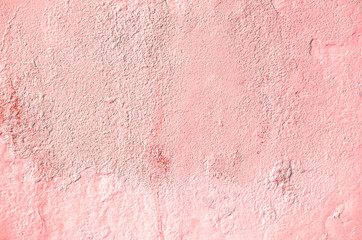 Fragment of old house wall close-up. Pink background. Peeling plaster on concrete surface. Cracks in paint. Copy space. Place for text. Selective focus image.