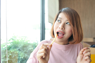 Asian women enjoy eatting french fries,selective focus