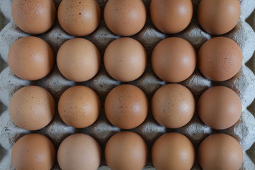 Raw chicken eggs in carton box on wooden table,Eggs background,top view.