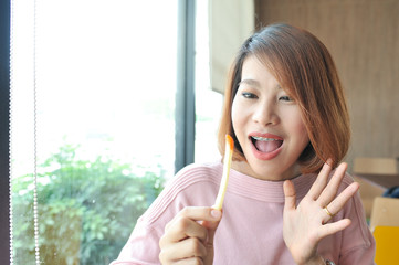Asian girl happy with her french fries,Women enjoy eating with her french fries,enjoy eating,french fries in hand