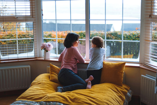 mother and daughter talking at window