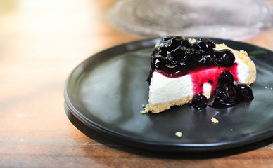 Relax time with coffee and cake,Blueberry Ceese pie cake put on black dish lay on wooden table,selective focus