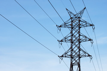 Power line against the blue sky. Energy, electricity, communication. High-voltage tower, line