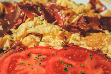 Scrambled eggs with bacon and tomato