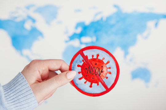 Corona Virus Concept. Watercolor image of prohibition sign with abstract virus strain model and text "NCOV" in woman's hand on background "Map of World"