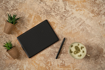 Mockup blank screen graphic tablet and cup of matcha latte. Flat lay yellow background office home working space. Designer workplace with graphic tablet